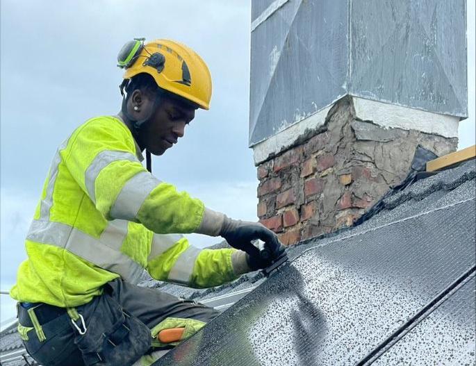 Lærling monterer solcelleanlegg på skråtak