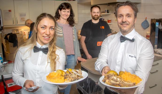 Svetlana Hansen og Ole Angellsen fra Bodø Energi Kraftsalg serverer gratis middag til sultne brukere av Kirkens Bymisjon i Bodø
